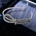 Dettaglio macro di un cerchietto in argento con fiocco di strass lucidi - Fascia Sottile Annodata con Strass Bianchi Completi