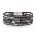 Detailed macro view of multilayered gray beaded bracelet with crystal chain and cross charm - Gray