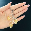 Detalle de colgantes de resina en forma de concha con lentejuelas doradas y estrellas - Amarillo