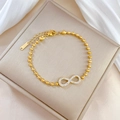 Dettaglio del bracciale con simbolo infinito dorato con cristalli e marchio S.Steel - Q107 Oro (Acciaio al Titanio) / Oro
