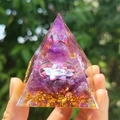 Hand holding a resin pyramid with purple crystal gravel, gold leaf, and a sphere - Style 3