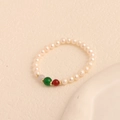 Elegantes Perlenarmband mit weißen Perlen, grünen, roten Steinen und goldenen Trennern - Weißes Süßwasserperlen-Armband