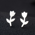 Macro shot of silver tulip-shaped stainless steel earrings on a black textured surface - Rose / Silver