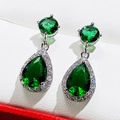 Macro detail of teardrop emerald zircon earrings on white leather display box - Green Zirconia