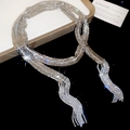Détail du collier à pampilles en strass avec finition argentée brillante sur fond sombre - Chaîne de Taille / Collier Long / Argenté