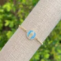 Macro-opname van 18K vergulde armband met Maagd Maria hanger en glinsterende zirkonia stenen - Cyaan