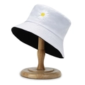 White cotton bucket hat with daisy embroidery and black lining on a wooden stand - One Size / White