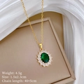 Detailopname van een gouden ketting met smaragd hanger en pavé kristallen op een doos - Ovale groene edelsteen hanger (F351)