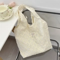 Détail du tissu jacquard 3D et de l'étiquette colorée sur ce grand sac crème - Sac Gilet Jacquard 3D Blanc Cassé