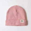 Pink knitted baby beanie with a white smiley face patch and ribbed warm texture - One Size / Pink