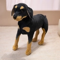 Realistisches schwarz-braunes Dobermann-Stofftier stehend auf einem weichen Teppich - 25cm