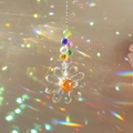 Close-up van kristallen zonnevanger die levendige regenboogpatronen op de muur werpt - Enkele Bloem Transparant