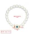 Detail view of pearl Evil Eye bracelet with 174mm inner perimeter and gold charm - Small Round Blue Eye Charm
