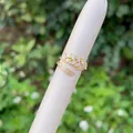 Detail of 18K gold wheat-shaped ring with marquise and baguette zircon stones - Geometric Layered Style