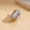 Detalle de un anillo ancho de metal plateado con textura geométrica irregular - Anillo - Plata