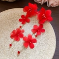 Detailed view of elegant long red fabric flower tassel earrings on a beige display plate - Red Chiffon Floral Long Tassel Style (38#银针) / Red