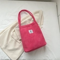 Rose red corduroy tote bag with woven handles and white leaf graphic patch on beige blazer - Pink