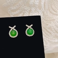 Macro view of green chalcedony studs with micro-set zircons on a black display stand - Gold Zircon Green Chalcedony Stud Earrings