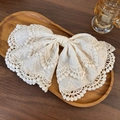 Eleganter cremeweißer Spitzen-Haarclip mit Schleife auf rustikalem Holztablett - Federclips / Gebrochenes Weiß