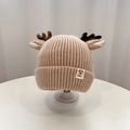 Close-up of knit baby hat with reindeer antlers on a minimalist display stand - Hat - Khaki