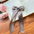 Elegant grey satin bow hair clip with long ribbons on vintage book background - Gray