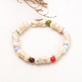 Ethno-Stil Keramik Knochen Armband mit bunten runden Perlen auf Leinenhintergrund - 11 Knochen Bunte Perlen
