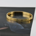 Primer plano del brazalete de acero de titanio dorado con textura de rejilla y grabados religiosos - Dorado