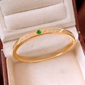 Macro detail of 18K gold-plated bangle featuring a green gemstone and pave-set zircons - 18K Gold Plated / Gold
