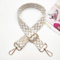 Macro detail of bohemian geometric woven strap with gold metal hooks and adjustable buckle - White Base Light Khaki
