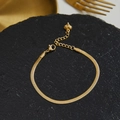 Collana piatta a serpente dorata con estensione a ciondolo a cuore su sfondo di pietra nera - Bracciale