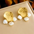 Golden irregular metal earrings with baroque pearls on a beige jewelry box with plants - Earrings (E6171)