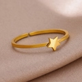 Macro shot of minimalist gold star open ring on textured champagne fabric background - Gold Star
