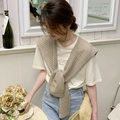 Dettaglio della trama a maglia dello scialle beige indossato sopra t-shirt e jeans - Color Tè al Latte