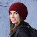Gorro de punto rojo oscuro con parche de montaña en un bosque invernal nevado - Burdeos