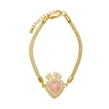 Detail of gold woven mesh bracelet featuring a pink heart charm with crown and zircon stones - Pink