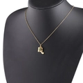 Detail of gold Scorpio zodiac necklace with green birthstone on black mannequin - 8-8 Scorpio