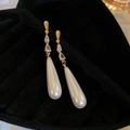 Detailed close-up of gold dangle earrings with teardrop zirconia and elegant white pearls - Gold White Teardrop Long