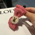 Detail einer Haarspange mit rosa Tweed-Schleife, weißem Plüschball und Goldhase - Rosa