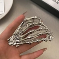 Nahaufnahme der silbernen Skeletthand Haarklammer aus Metall in der Hand gehalten - Silber
