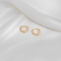 Detail of gold hoop earrings with pink enamel polka dots on a white silk background - White