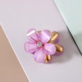 Macro shot of purple resin flower hair claw with gold metal base and center rhinestone - Crystal Glitter Style / Purple