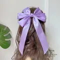 Detail einer seidigen lila Haarschleife mit langen Bändern an einer eleganten Frisur - Lila