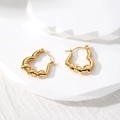 Macro shot of gold-plated geometric heart earrings with unique twisted metal texture detail - Twisted Heart