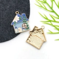 Detailed close-up of a blue enamel house pendant with gold trim and floral patterns - Drip Oil Blue Mushroom Flower House