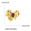 Elegante broche de mariposa dorado con gema roja y pedrería rosa con dimensiones - Oro Circonita Violeta