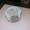 Detailed macro of a triple-row pearl bracelet featuring a sparkling crystal clover clasp - 2# Bracelet-White Flower
