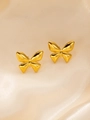 Makro-Detail von hochglanzpolierten goldenen Schmetterling-Ohrsteckern auf Seide - Goldene Schmetterling Ohrstecker