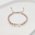 Detail of hand-woven light pink rope bracelet with golden letter F charm and pearl - Letter F
