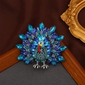 Elegant peacock brooch with blue crystals and enamel feathers on a vintage background - Funny Turkey / Blue