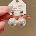 Gros plan détaillé d'une boucle d'oreille en grosse perle blanche et cuivre doré - Style Blanc (58#)